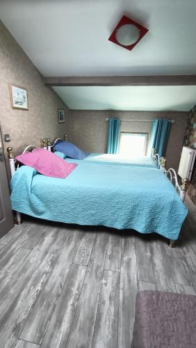 a bedroom with a large bed with blue sheets at Les Ponts de l'Ornain in Bar-le-Duc