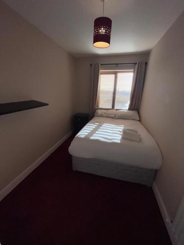 a small bedroom with a bed and a window at North Dublin Modern Apartment in Dublin