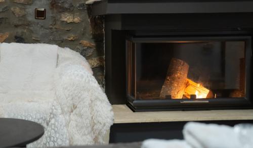 a fireplace in a living room with a fire at kaimak luxury chalet in Palaios Agios Athanasios