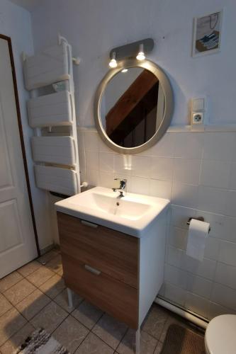 une salle de bain avec un lavabo et un miroir dans l'établissement Charmante Maison de ville à 6 km de la mer, à Lanmeur