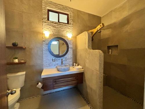 ein Badezimmer mit Waschbecken und Spiegel in der Unterkunft Casa blanca playa saladita in Temalhuacán