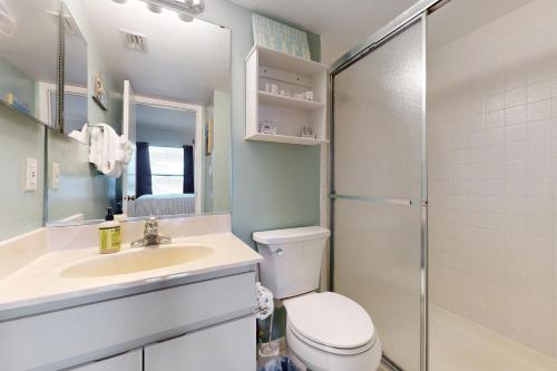 a bathroom with a toilet and a sink and a shower at Cape Palms in Cape Canaveral