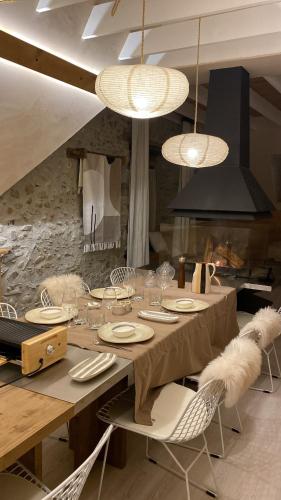 - une salle à manger avec une table, des chaises et des lumières dans l'établissement Casa Neste: Grange rénovée haut de gamme, à Arreau