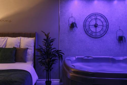 een paarse slaapkamer met een bed en een bad bij Riverside studio with Jacuzzi! in Sheffield