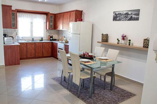 eine Küche mit einem Tisch und Stühlen sowie einem Kühlschrank in der Unterkunft Διαμέρισμα στη χλόη Καστοριάς in Kastoria