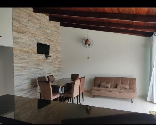 a living room with a table and a couch at Rancho lago azul in Guapé