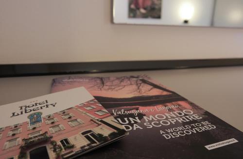 two magazines sitting on top of a table at Hotel Liberty in Levico Terme