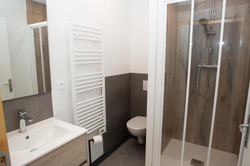 a bathroom with a toilet and a sink and a shower at Appart Hotel Coutances in Coutances