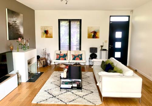 a living room with a white couch and a rug at Maison au calme à 20 min du centre de Paris in Nanterre