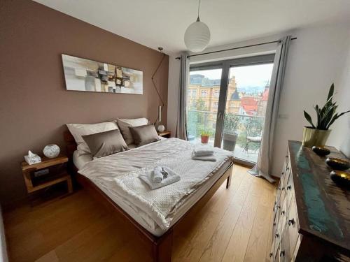 1 dormitorio con cama y ventana grande en Apartment in historical center with park view en Plzeň