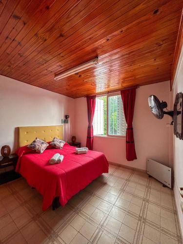 a bedroom with a red bed with a wooden ceiling at Almma Mia in Godoy Cruz