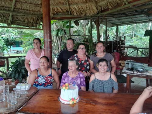 un grupo de personas de pie alrededor de una mesa con un pastel en Paraíso Tropical Boca del Silencio, 