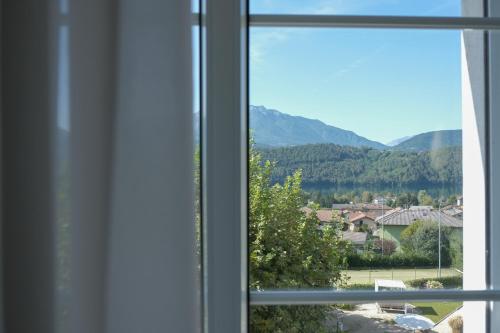 a window with a view of a town and mountains at Hotel Liberty in Levico Terme