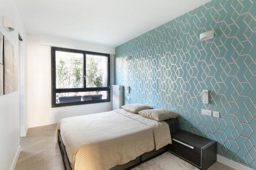 1 dormitorio con cama y pared azul en Loft 52m²+parking à 15 min de Paris centre, en Les Lilas