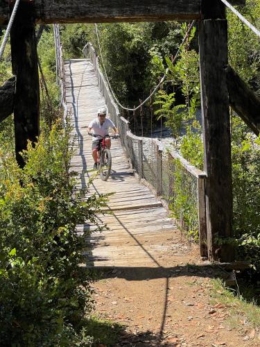 a man riding a bike on a wooden trail at Barraco Lodge in Puelo
