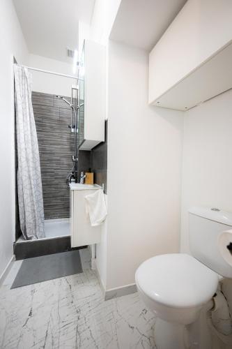 une salle de bain blanche avec toilettes et douche dans l'établissement Jade - Appart Design au coeur de Marseille, à Marseille