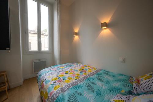 une chambre avec un lit avec une couette dessus dans l'établissement Jade - Appart Design au coeur de Marseille, à Marseille