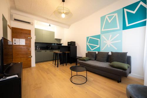 un salon avec un canapé et une cuisine dans l'établissement Jade - Appart Design au coeur de Marseille, à Marseille