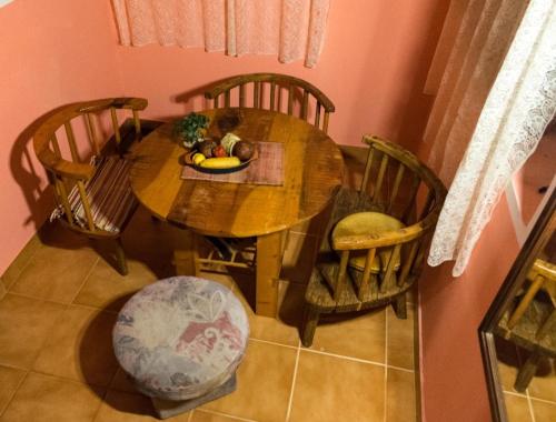 een houten tafel met stoelen en een fruitschaal erop bij Marija home in Kolašin