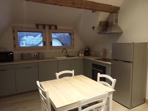 Una cocina con una mesa de madera y un refrigerador. en la grande ourse, en Planay