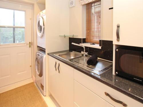 a kitchen with a sink and a microwave at 4 Bed in Druridge Bay CN102 in Hadston