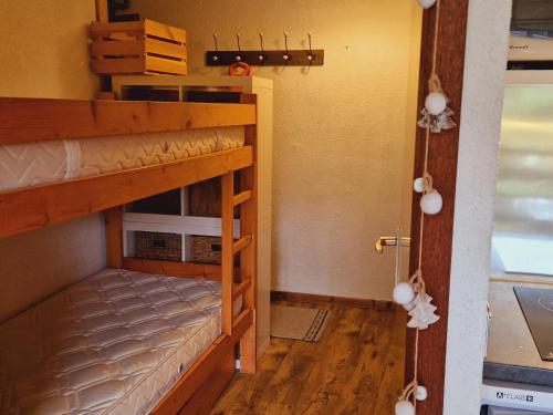 Cette chambre comprend 2 lits superposés et une porte. dans l'établissement Studio cosy pour 4 pers., proche pistes et commerces, Aime-La-Plagne - FR-1-755-10, à Aime La Plagne