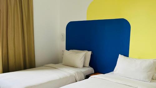 two beds sitting next to each other in a room at Ganalé Hôtel in Dakar