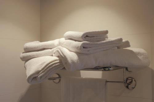 a pile of towels on a towel rack in a bathroom at Hotel Liberty in Levico Terme