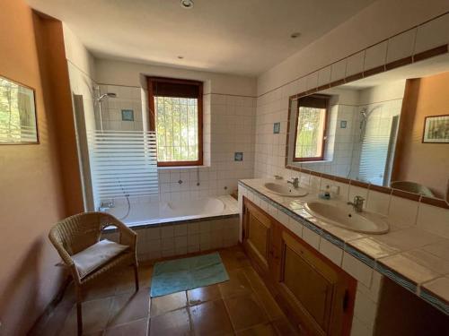 une salle de bain avec deux lavabos et une baignoire dans l'établissement Belle Maison en Provence, à Sérignan-du-Comtat