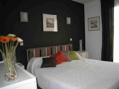 une chambre avec un lit et un vase de fleurs sur une table dans l'établissement JARDIN DE CAMILLE LLAURO, à Llauro