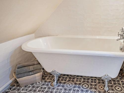a white bath tub in a bathroom with a tile floor at 3 Bed in Govilon 59730 in Govilon
