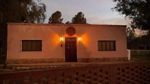 a small white building with a door in front at El Cortijo Tinogasta in Tinogasta