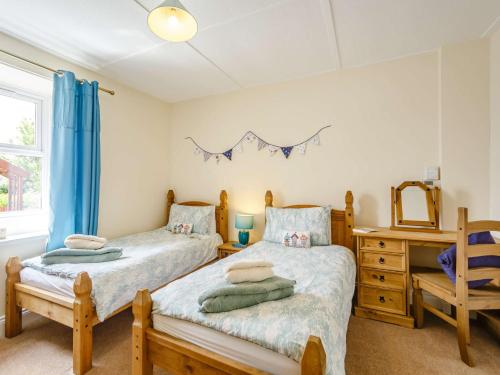 a bedroom with two twin beds and a mirror at 2 Bed in Boulmer 60464 in Boulmer