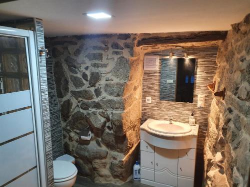 a stone bathroom with a sink and a toilet at casa cristimil -san amaro in Salamonde
