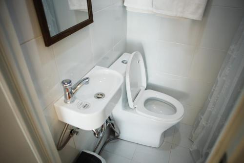 a bathroom with a white toilet and a sink at Nana's Beach Surigao in Surigao