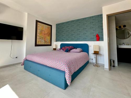 um quarto com uma cama azul e uma parede em Laureto BnB em Roquebrune-Cap-Martin