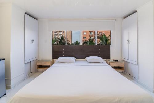 Villa Santos Apartaestudios في بارانكويلا: غرفة نوم بيضاء كبيرة مع سرير كبير