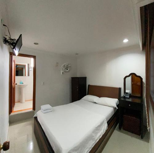 una camera con letto, specchio e lavandino di Hotel Sangil Tuluá a Tuluá