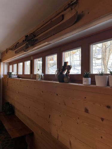 - un comptoir en bois avec des fenêtres dans l'établissement Maison Rododendro Elegant, à Breuil-Cervinia
