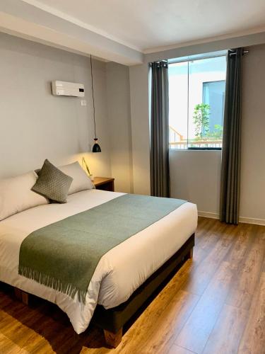 a bedroom with a bed and a large window at Casa Encuentro San Blas in Cusco