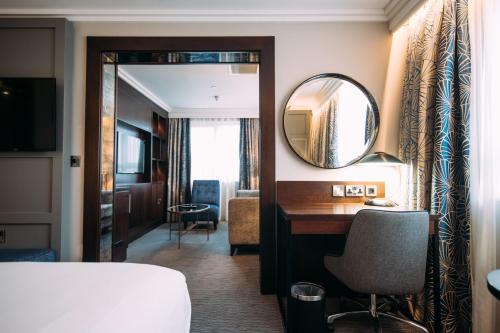 a hotel room with a mirror and a desk at Crowne Plaza - Belfast by IHG in Belfast