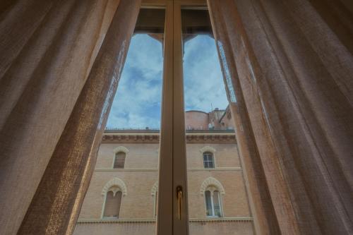 a view of a building through a window at Suite in the center of Bologna in Bologna