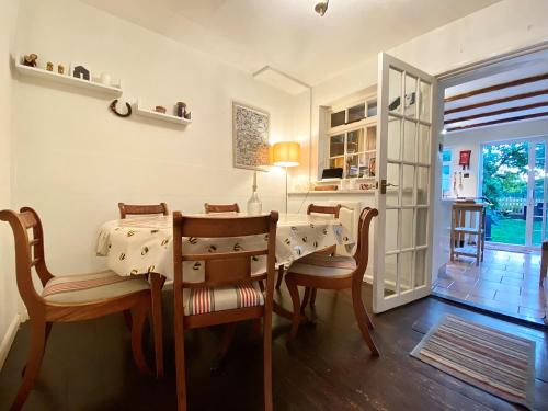 a dining room with a table and chairs at Bumblebee Cottage - Cosy Cottage in Area of Outstanding Natural Beauty in Hemel Hempstead