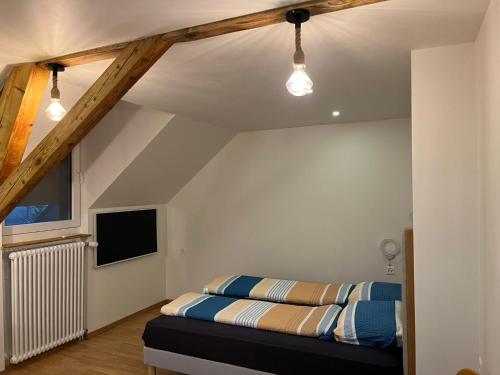 a bedroom with a bed and a tv on the wall at Studio cosy au centre de Couvet in Couvet