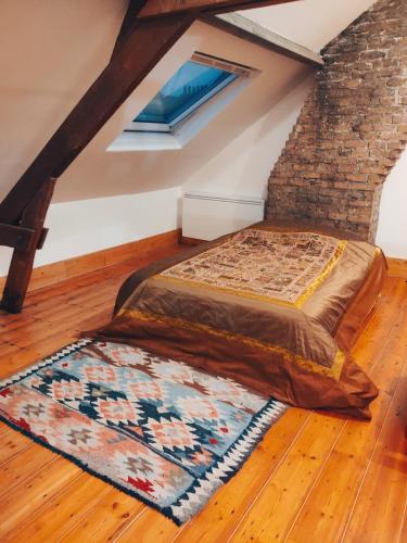 un lit dans une chambre avec un mur de briques dans l'établissement Jolie Maison en Bois Authentique, à Dunkerque