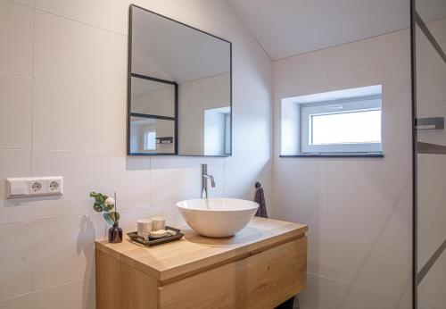 a bathroom with a bowl sink and a mirror at Barn24 - The Sty in Roggel
