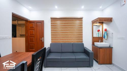 a living room with a blue couch and a mirror at F3 Homes in Cochin