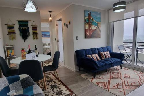 uma sala de estar com um sofá azul e uma mesa em Departamento nuevo en Villarrica em Villarrica
