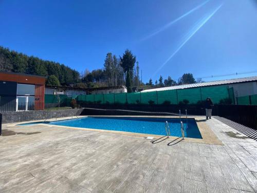 a person standing in front of a swimming pool at Departamento nuevo en Villarrica in Villarrica