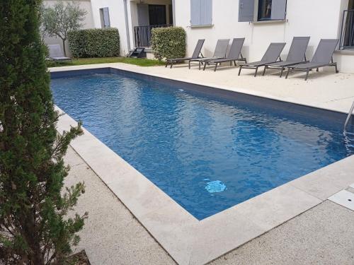 - une piscine avec des chaises dans une maison dans l'établissement le clos du ventoux, à Malaucène